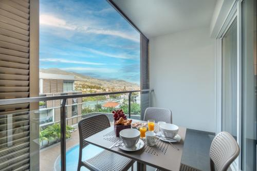 a dining room with a table with a view of a balcony at Gardenia Apartment by LovelyStay in Funchal