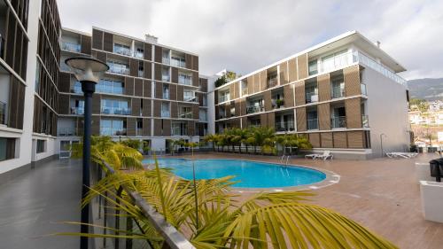 an apartment complex with a swimming pool in front of a building at Gardenia Apartment by LovelyStay in Funchal