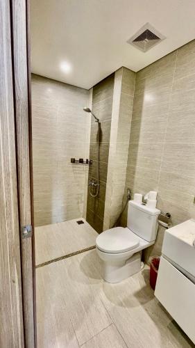 a bathroom with a toilet and a shower at Vinsmart City Cam Cam homestay in Phú Thú