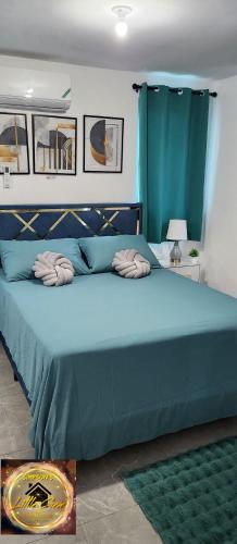 a blue bed with two pillows on top of it at Simpsons Little Gem 2 in Kingston