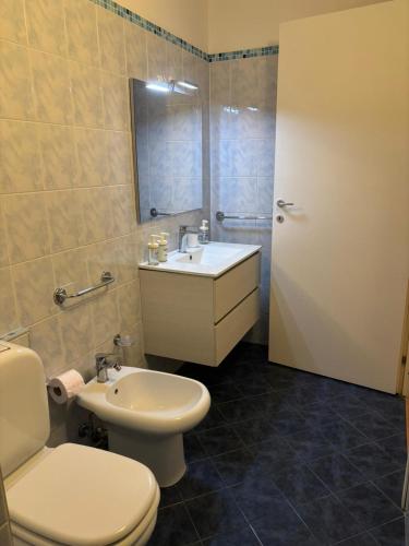 a bathroom with a white toilet and a sink at Downtown Living in Catania