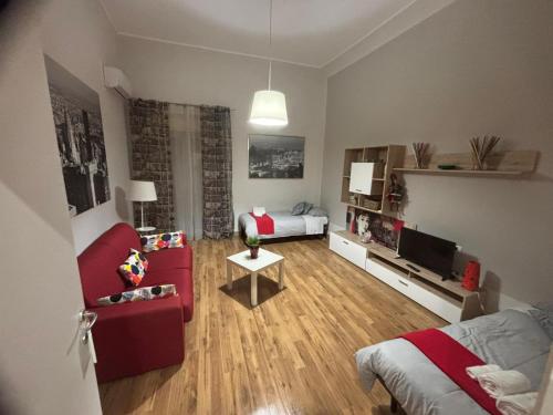a living room with a red couch and a bed at Downtown Living in Catania