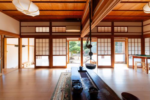 a living room with wooden ceilings and windows and a table at Wakamizu Minpaku in Tōgane