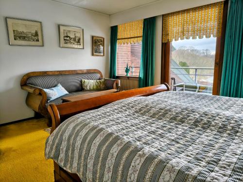 a bedroom with a bed and a couch and a window at Sæbygaard Estate Kalundborg in Ruds-Vedby