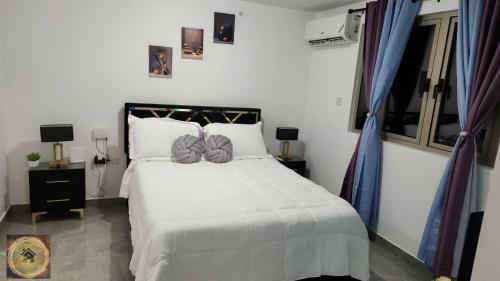 a bedroom with a bed with white sheets and pillows at Simpsons Little Gem 1 in Kingston