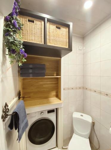 a small bathroom with a toilet and a washing machine at Romantic Old Town Hideaway in Haapsalu