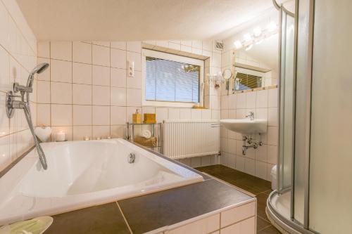 ein Badezimmer mit einer großen Badewanne und einem Waschbecken in der Unterkunft Appartement Stuibenfallblick in Umhausen