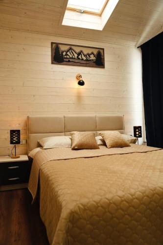 a bedroom with a large bed with two lamps on it at Легіт in Khashchovanoye