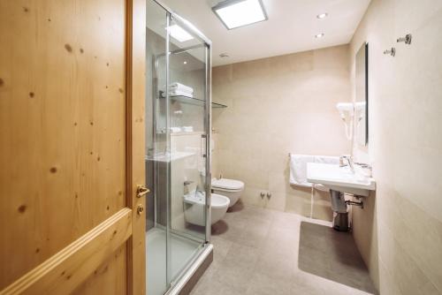a bathroom with a toilet and a glass shower at Schloss Hotel & Spa Pontresina in Pontresina