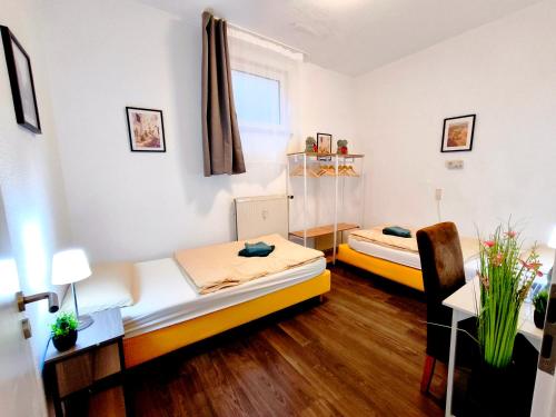 a room with two beds and a desk in it at Schwert City Loft S41 2 BAD 2 WC 4 Schlafzimmer in Verden