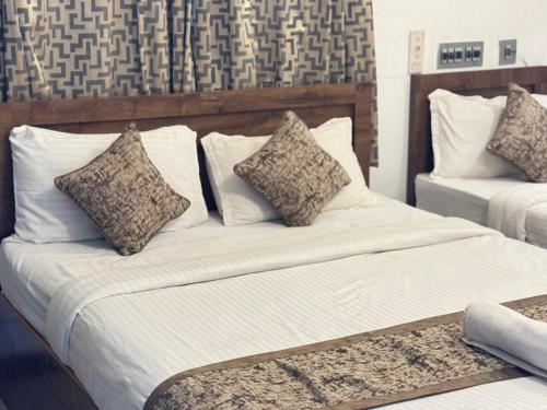 a bedroom with two beds with pillows at La Paradise Residency - TIE Hotels in Pondicherry
