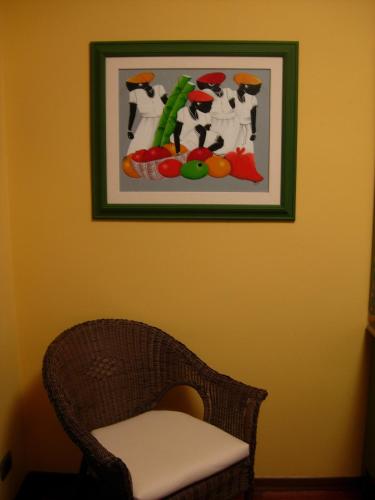 a picture of fruits and vegetables on a wall with a chair at Villa Clementine in Piazza Armerina