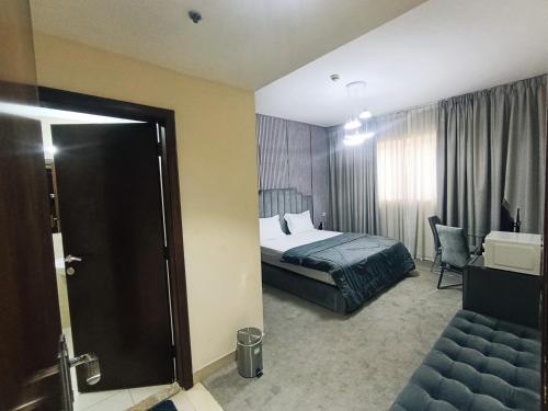 a hotel room with a bed and a chair at ApartHotel Rooms in Ajman