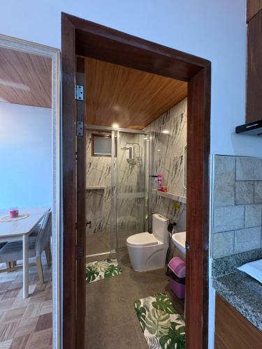a bathroom with a shower and a toilet and a table at Sonnenblume Homestay in General Luna