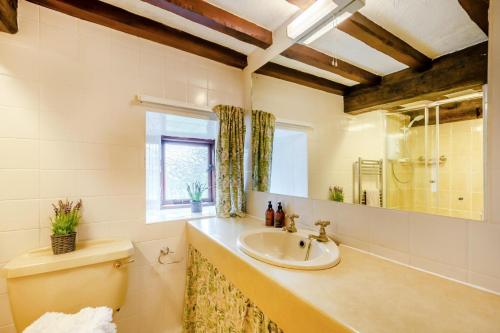 a bathroom with a sink and a toilet and a window at 4 Bed in Satterthwaite oc-c32334 in Grizedale