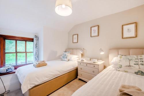a bedroom with two beds and a window at 4 Bed in Satterthwaite oc-c32334 in Grizedale
