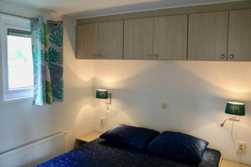 a bedroom with a bed and two lamps and a window at Cottage Jardenne 6p 3Bdrms in Grupont