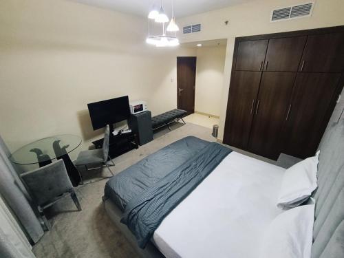 a bedroom with a bed and a desk with a computer at ApartHotel Rooms in Ajman