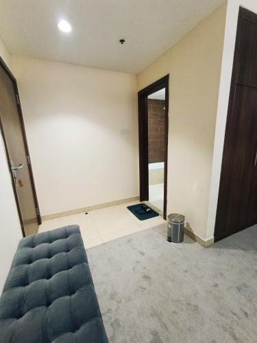 a living room with a couch and an open door at ApartHotel Rooms in Ajman