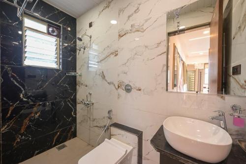a bathroom with a sink and a mirror at Vrundavan Villa Lonavala in Malavli