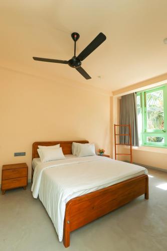 a bedroom with a bed with a ceiling fan at Allude Villa Weligama in Weligama