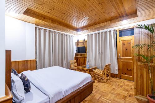 a bedroom with a bed and a table and chairs at Manali Parvat View in Jagatsukh
