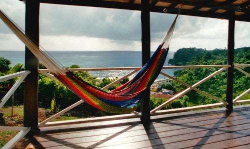 a hammock on a deck with a view of the ocean at I VIEW - in Long Bay in Long Bay Village