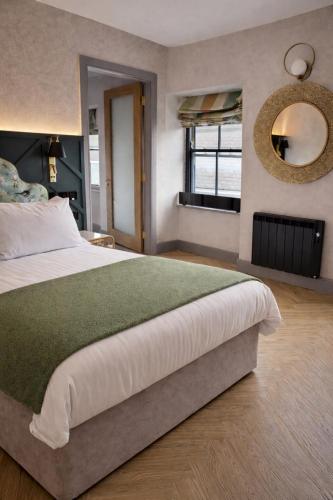 a bedroom with a large bed and a mirror at The Tholsel Bar and Townhouse Kilkenny in Kilkenny