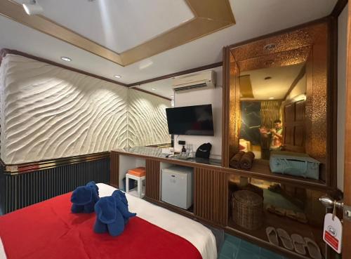 a bedroom with a large bed with a red blanket at Miracle Beach Club Resort With Luxury Sunbeds include Free credit for redeemable food & drinks in Trat