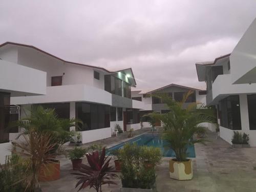 Un edificio de apartamentos con piscina y palmeras. en Casa en Tonsupa, en Tonsupa