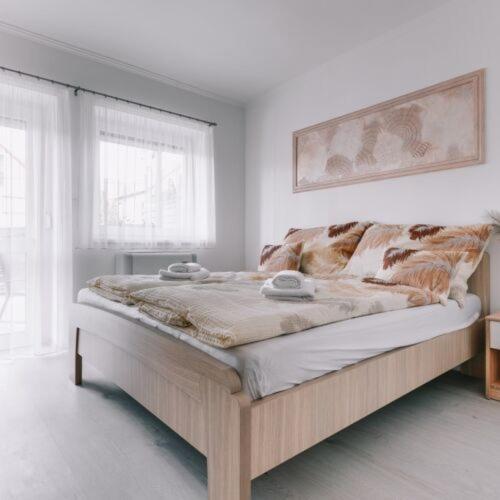 a bed in a white room with at Békeapartmanház in Badacsonytomaj