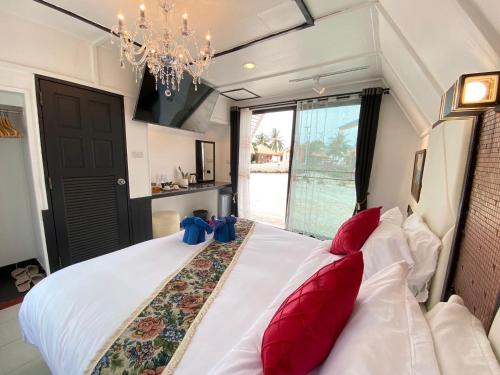 a bedroom with a large white bed with red pillows at Miracle Beach Club Resort With Luxury Sunbeds include Free credit for redeemable food & drinks in Trat
