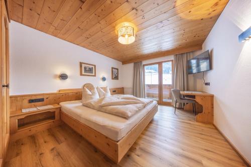 a bedroom with a bed and a desk in a room at Ausserwieserhof in Neustift im Stubaital