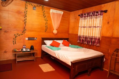 a small bedroom with a bed and a window at Comfort Treehouse Pidurangala in Dambulla