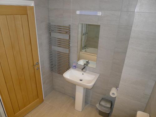 a bathroom with a sink and a mirror and a toilet at Church Court Apartments in Rugby