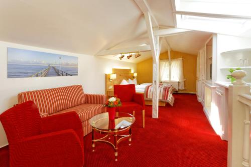 a hotel room with a couch and a bed at Hotel Sonneneck in Zinnowitz