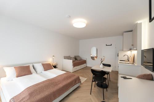 a white bedroom with a bed and a desk at Studio 4 in Bad Schallerbach