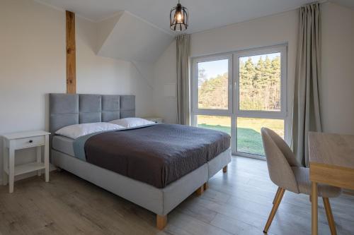 a bedroom with a bed and a desk and a window at Agroturystyka Milówka in Jagodzin
