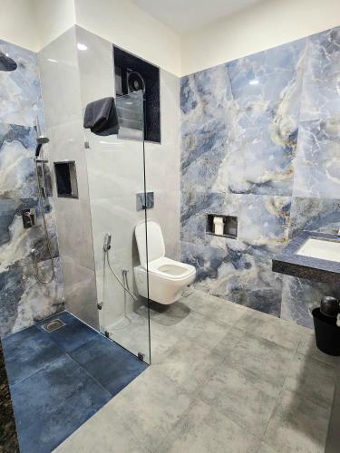 a bathroom with a shower with a toilet and a sink at La Vida Colva Beach Resort in Colva