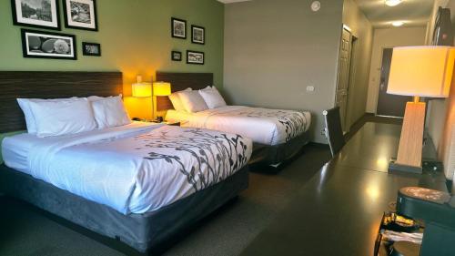 a hotel room with two beds and two lamps at Express Inn & Suites in Harrisburg