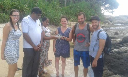 a group of people standing on the beach at Peacock Residence & Cabana's in Tangalle