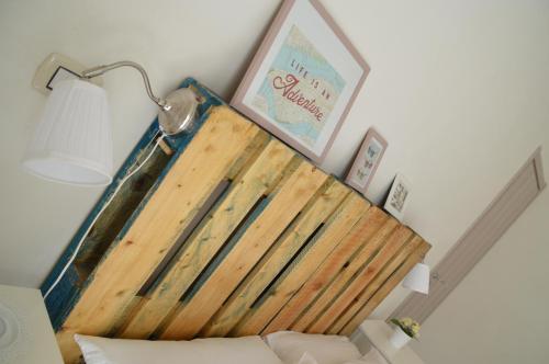 a bed with a wooden headboard in a room at B&B La Via di Casa in San Leone