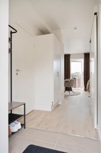 a living room with white walls and a table at Luxurious apartment in central Grebbestad! in Grebbestad