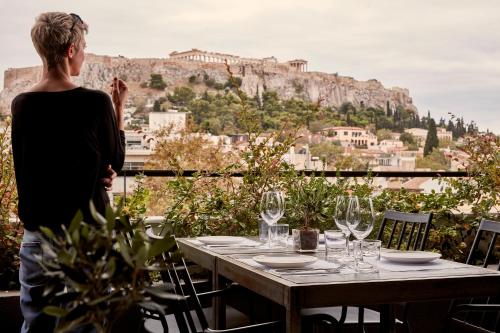 una donna in piedi davanti a un tavolo con bicchieri da vino di The Zillers Boutique Hotel ad Atene