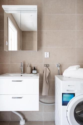 a bathroom with a sink and a mirror and a washing machine at Luxurious apartment in central Grebbestad! in Grebbestad