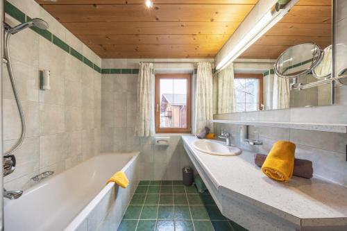 a bathroom with a tub and a sink and a mirror at Ausserwieserhof in Neustift im Stubaital