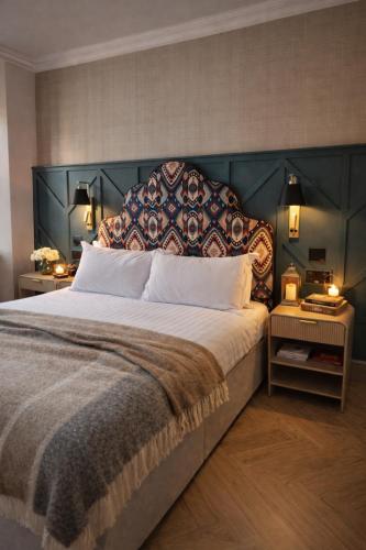 a bedroom with a large bed with a large headboard at The Tholsel Bar and Townhouse Kilkenny in Kilkenny