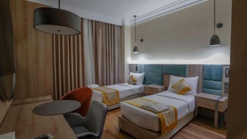 a hotel room with two beds and a chair at فندق رؤيا الاندلس النخبة - Roaya Alandalus Elite Hotel in Medina
