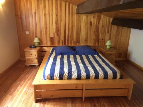 a bedroom with a bed in a room with wooden walls at Gite Loisirs Provence in Annot