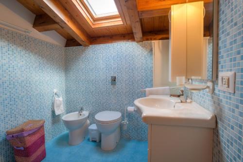a bathroom with a sink and a toilet and a window at Appartamenti Pomelia Punta Secca in Punta Secca